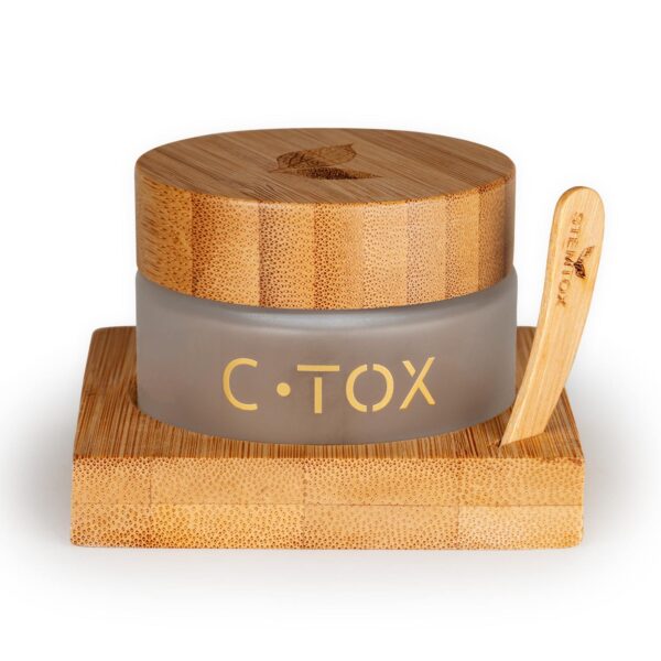 A jar of C.TOX sits on a bamboo stand. It has a bamboo lid and a bamboo applicator