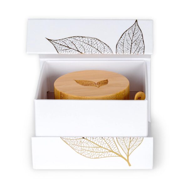 The product box is propped open, showing the top of the product jar and its bamboo lid